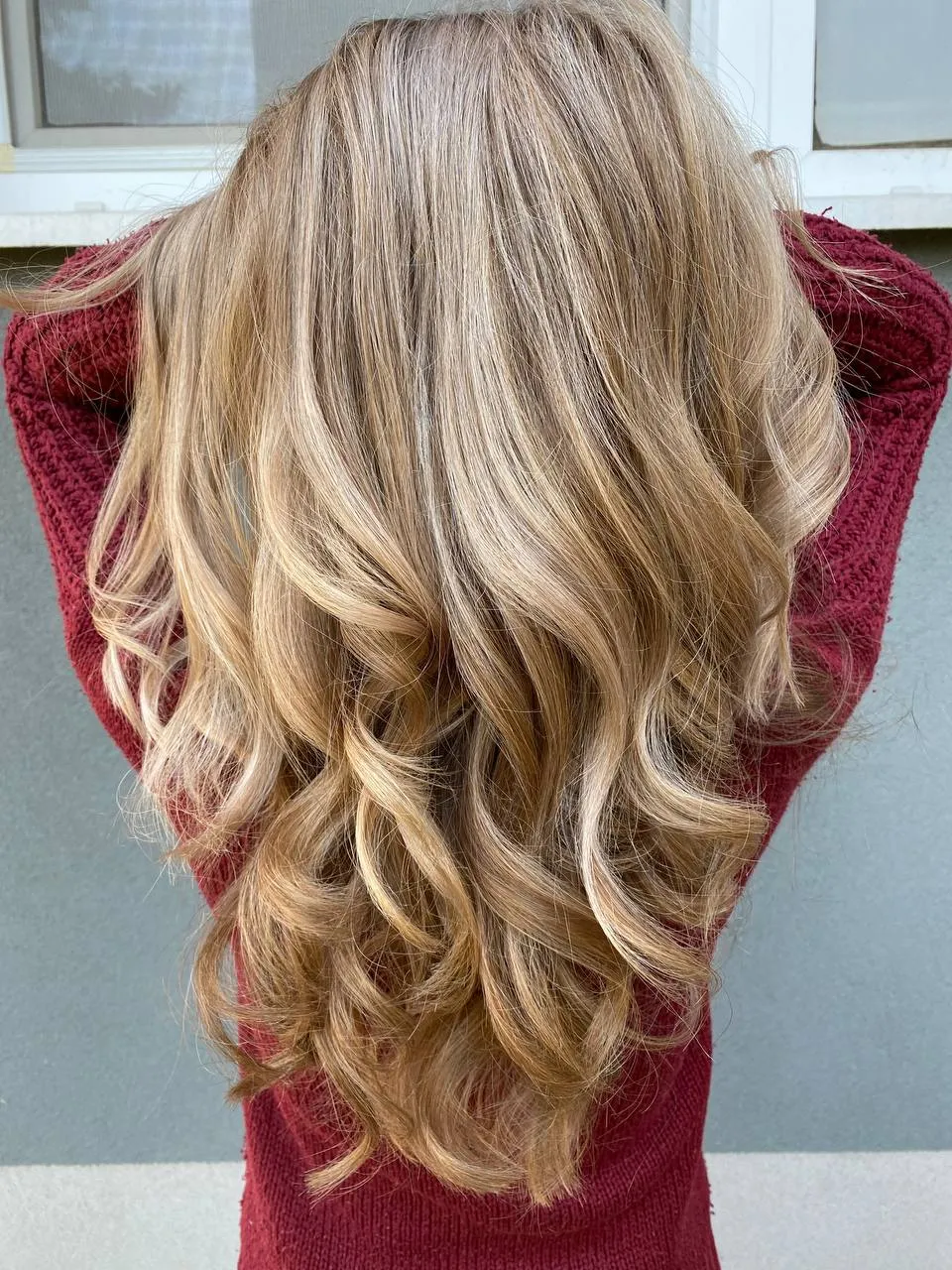 Zlatavé balayage vlny zezadu, vínový svetr — salon Newtone Brno